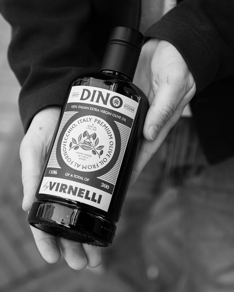 Handen houden een fles olijfolie van Virnelli vast