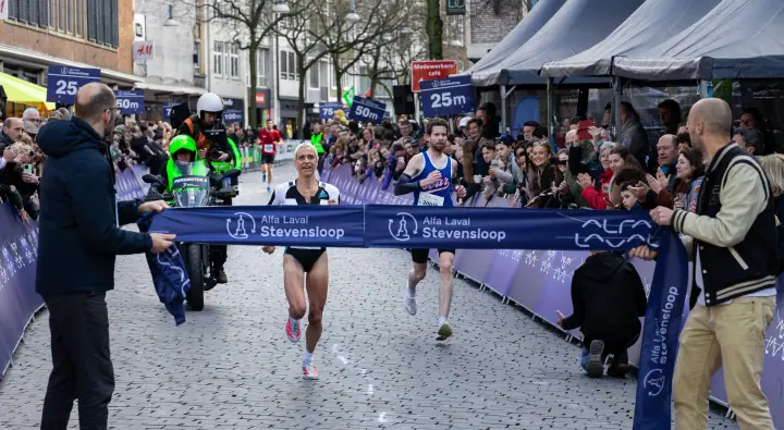 Winnares vlak voor het lint van de Alfa Laval Stevensloop, een begeleidende motor achter haar