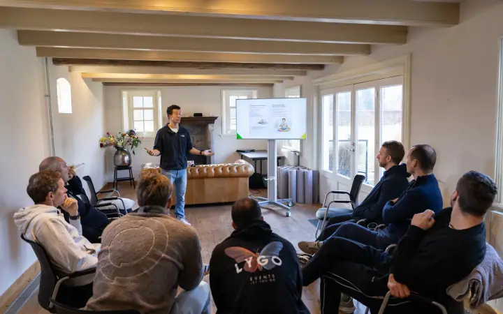 Eventfotografie van de Chakana Coaching workshop, de groep zit in een halve kring terwijl de coach vertelt.