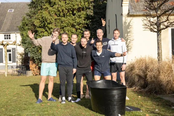 Dezelfde groep zwaait en steekt de duim op naar de camera, vrolijk in de winterzon.