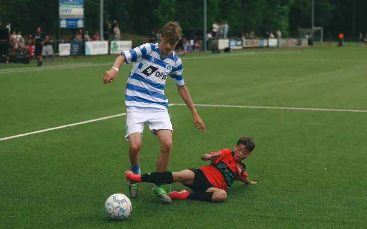 NEC-speler glijdt in op de bal, maar de speler van De Graafschap houdt hem nog net bij zich