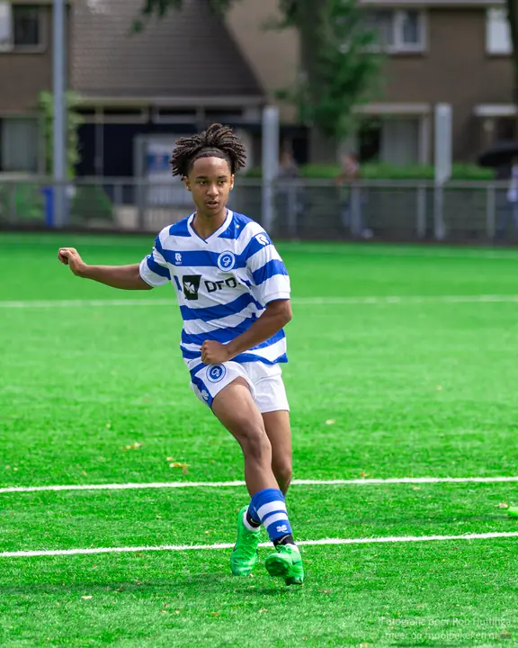 Jeugdspeler van De Graafschap in volle sprint over het kunstgras, armen pompend