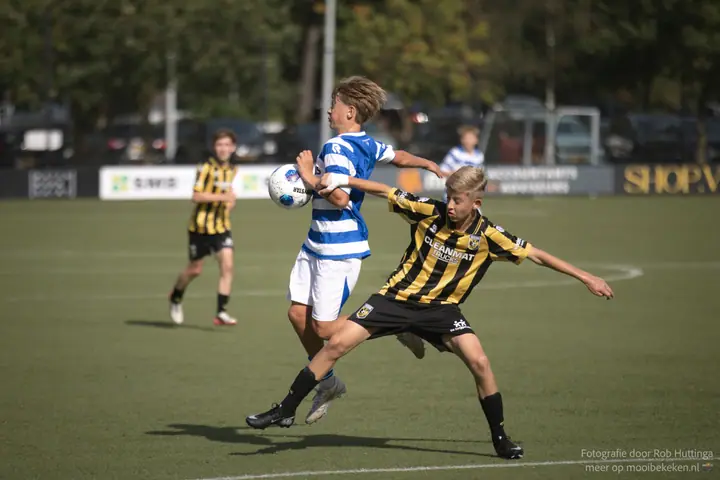 Balaanname op de borst onder druk van een verdediger van Vitesse in geel-zwart