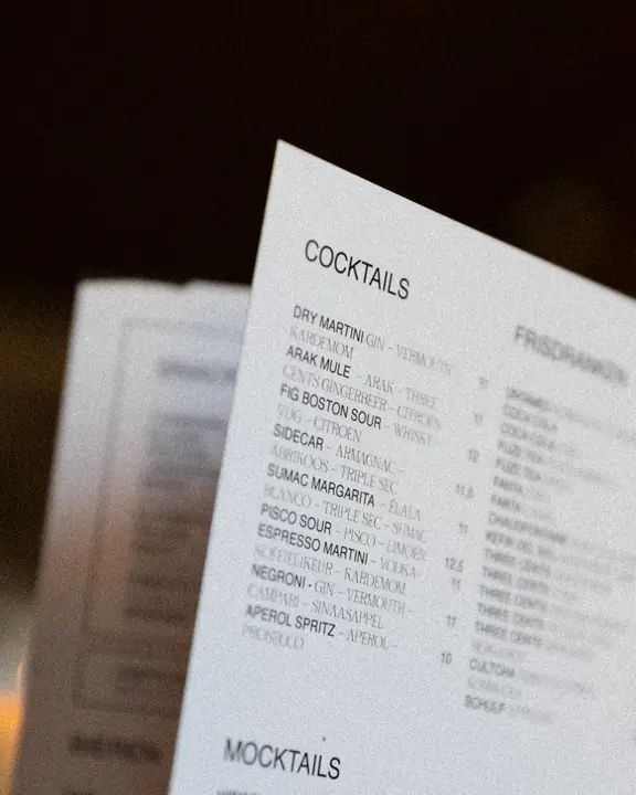 Close-up van de cocktailkaart van Jadda, met onder meer een Arak Mule en een Sumac Margarita