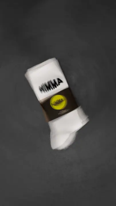 Nieuwe sokken van Nimma Running Club op een donkergrijze achtergrond, licht vervaagd voor dynamiek