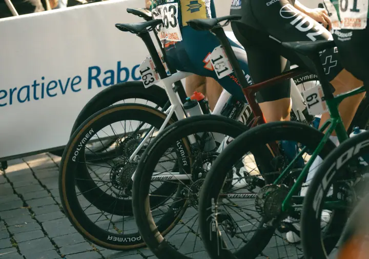 Rij racefietsen met carbon wielen en rugnummers op de kasseien bij de start in Nijmegen