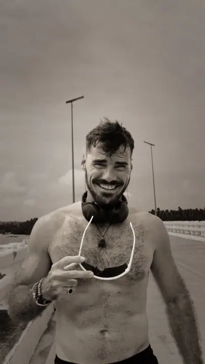 Lukas lacht breeduit na het lopen, koptelefoon om zijn nek en bril in de hand