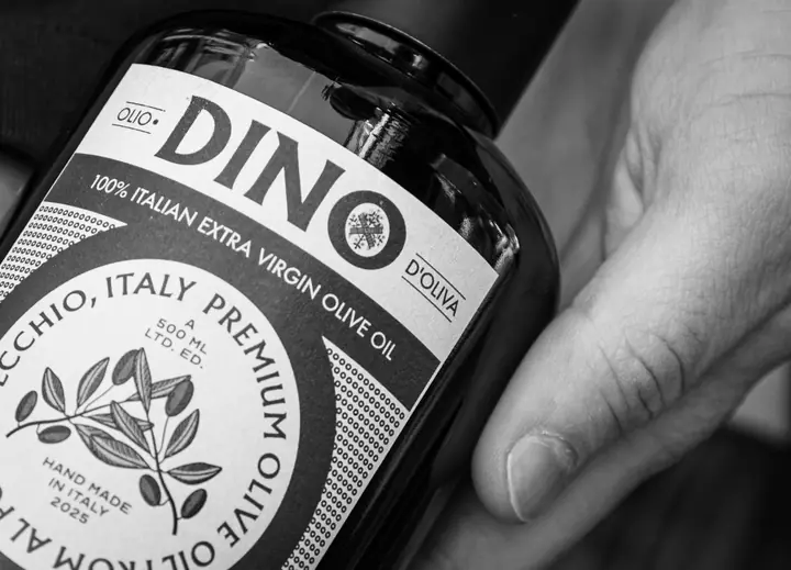 Het DINO-etiket in zwart-wit, met de getekende olijftak van dichtbij