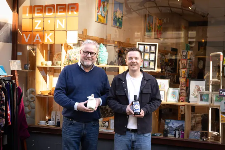 Twee mannen met Virnelli olijfolie in de hand voor de etalage van een winkel
