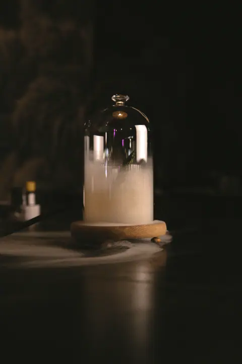 Rokerige cocktail onder een glazen stolp op de bar van YUCA Cocktailbar Nijmegen